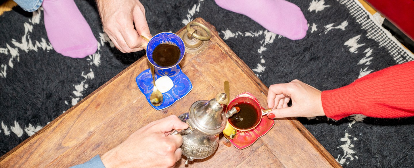 Två personer håller varsin fylld kaffekopp