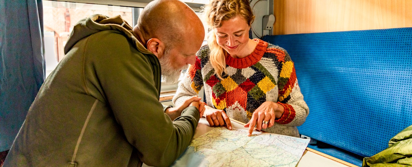 Bilden visar en man och en kvinna på tåg