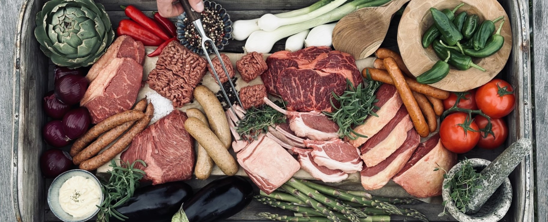 Låda fylld med ekologiskt kött, korvar och grönsaker