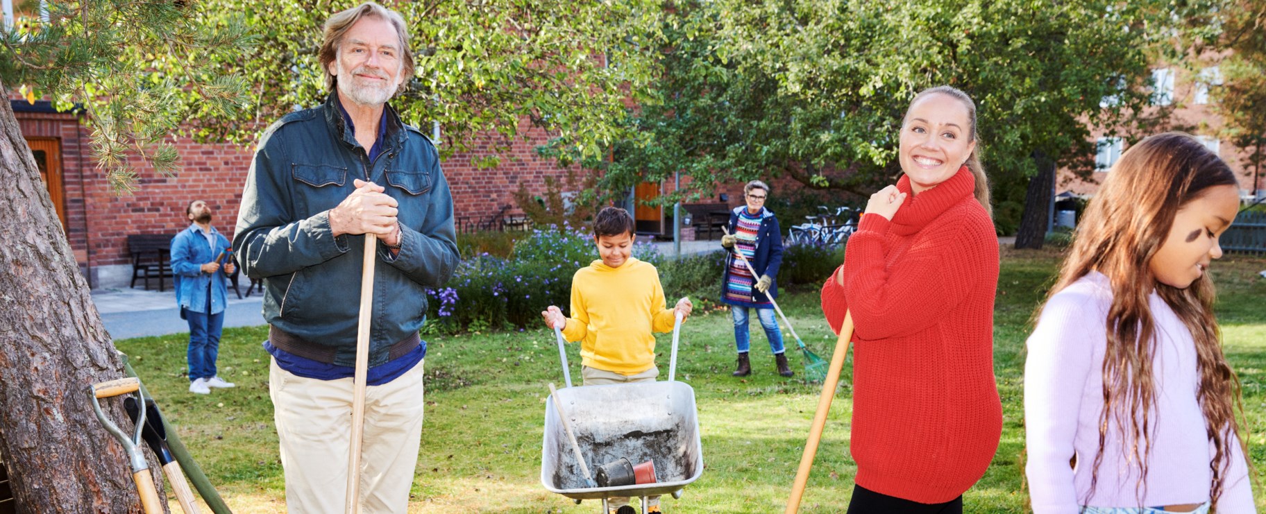 En man som står med ett trädgårdsredskap ute på gården