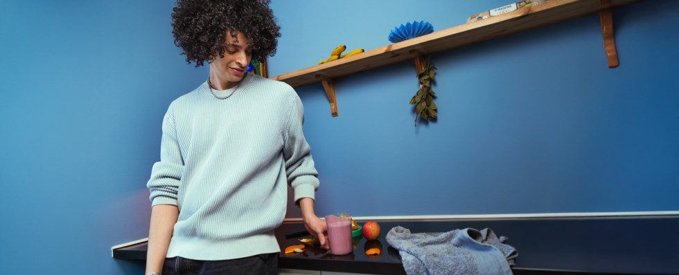 Ung man gör smoothie