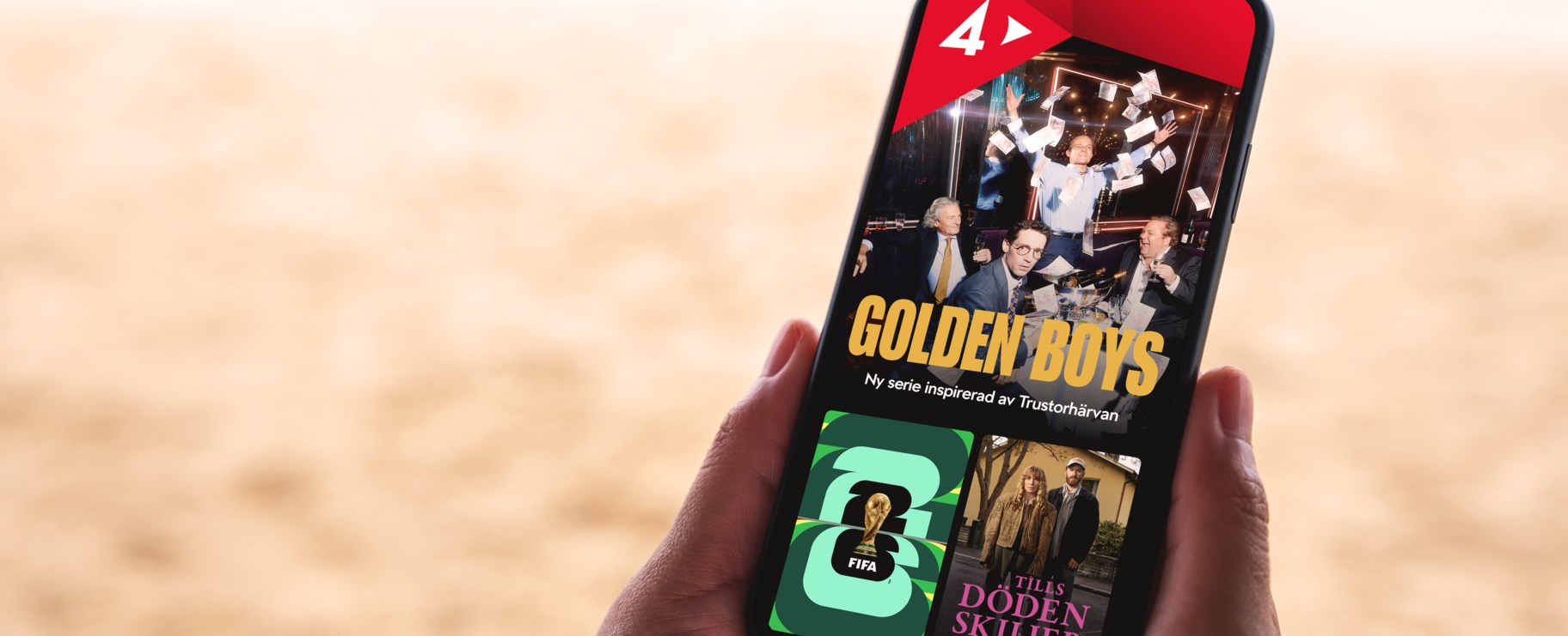 En mobiltelefon hålls i händerna på en strand, på skärmen visas serierna Golden Boys och Tills döden skiljer oss åt tillsammans med FIFA Fotbolls VM
