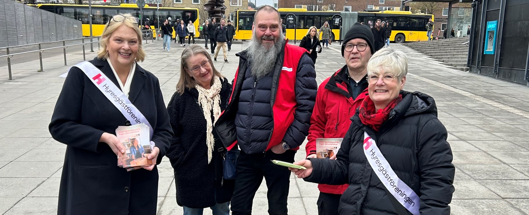 Fem personer på torget i Uppsala delar ut rapport om jämställdhet