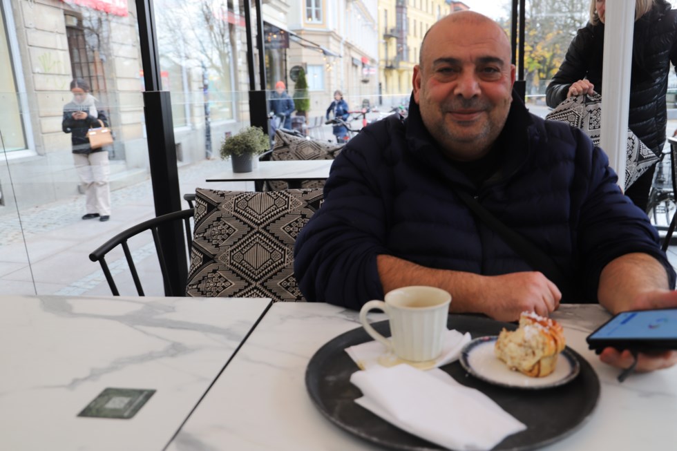 Man med telefon och kaffekopp