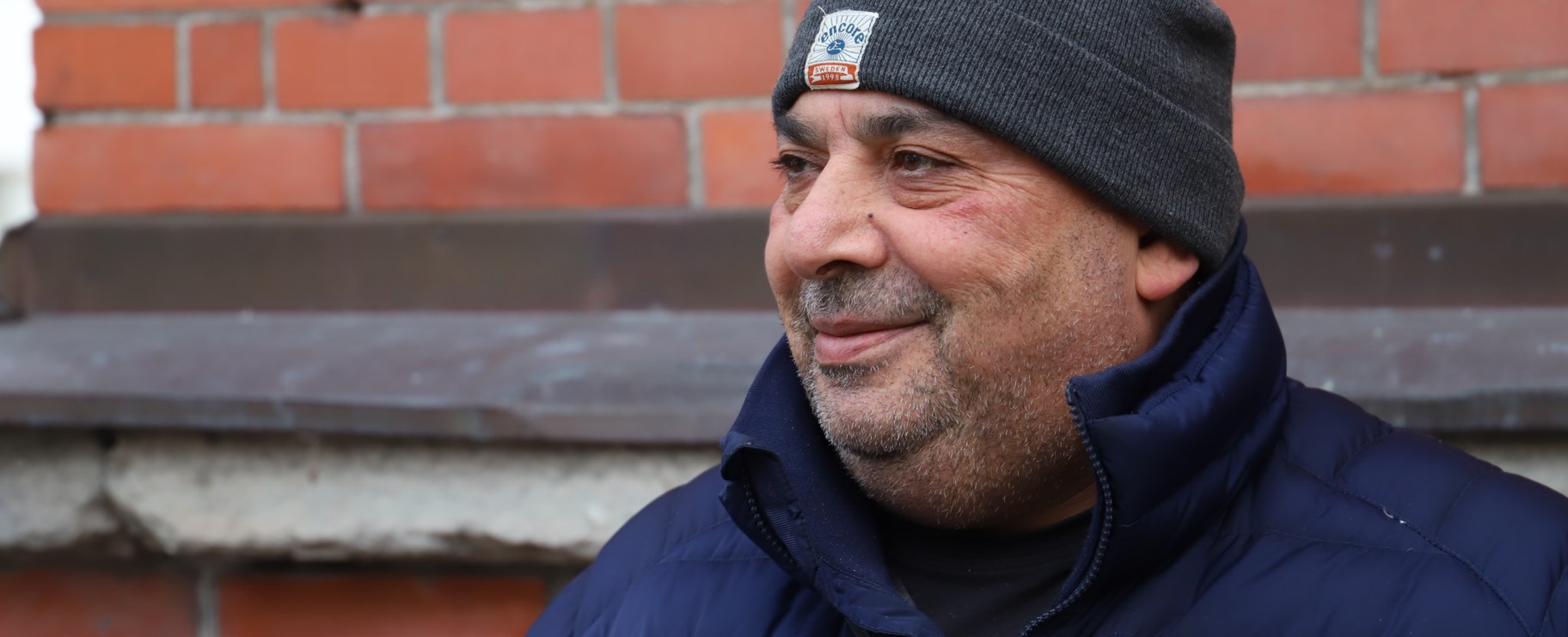 man framför husvägg