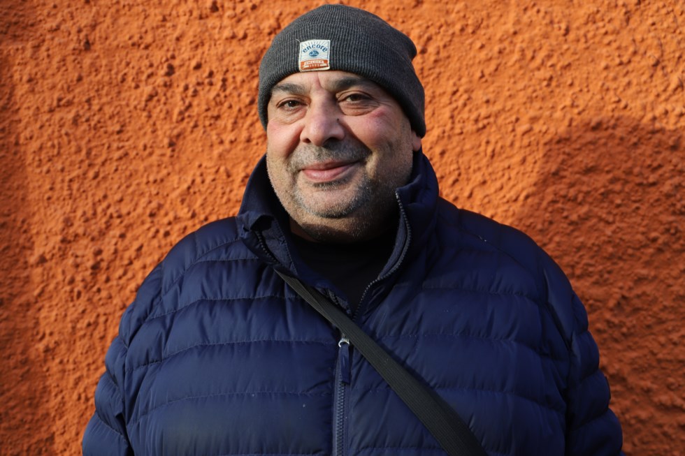 man framför husvägg