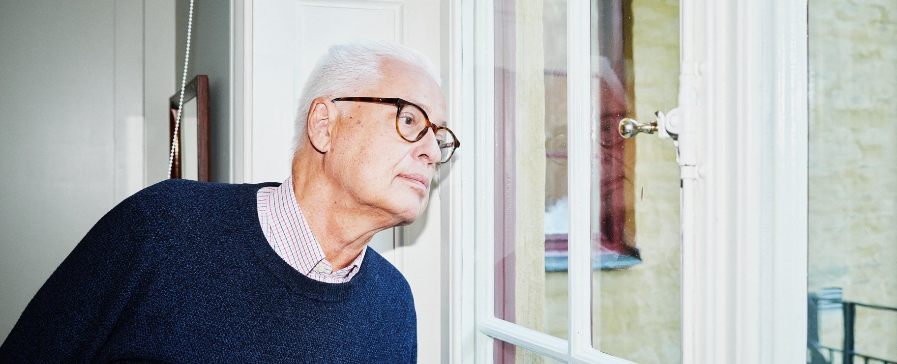 Man tittar ut genom fönstret