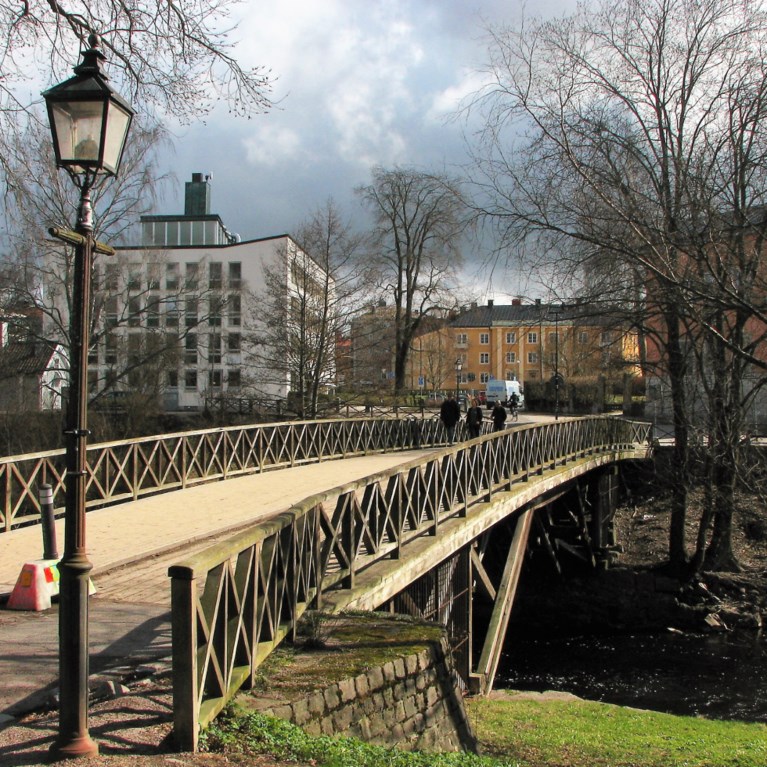 Bro över Gävleån i solljus med gatlykta i förgrunden