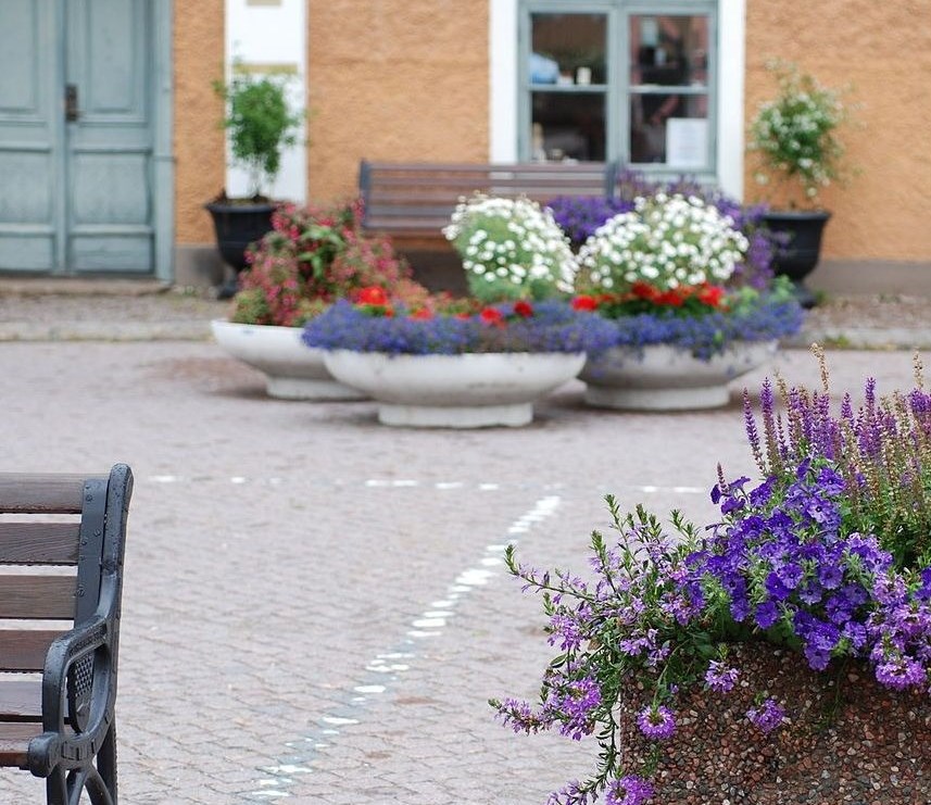 Bänkar och blomsterkrukor på ett torg