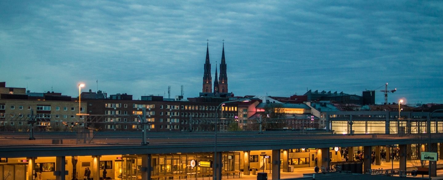 Centralstationen i vackert nattljus med Domkyrkans torn i siluett i bakgrunden