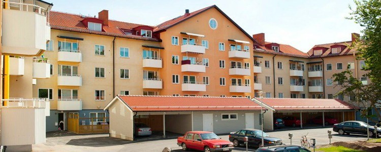 Bostadshus i sol med garagelänga framför