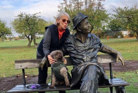 Kvinna vid staty med hund.