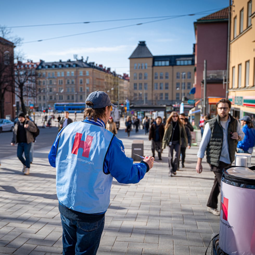 En person från Hyresgästföreningen delar ut flygblad på stan