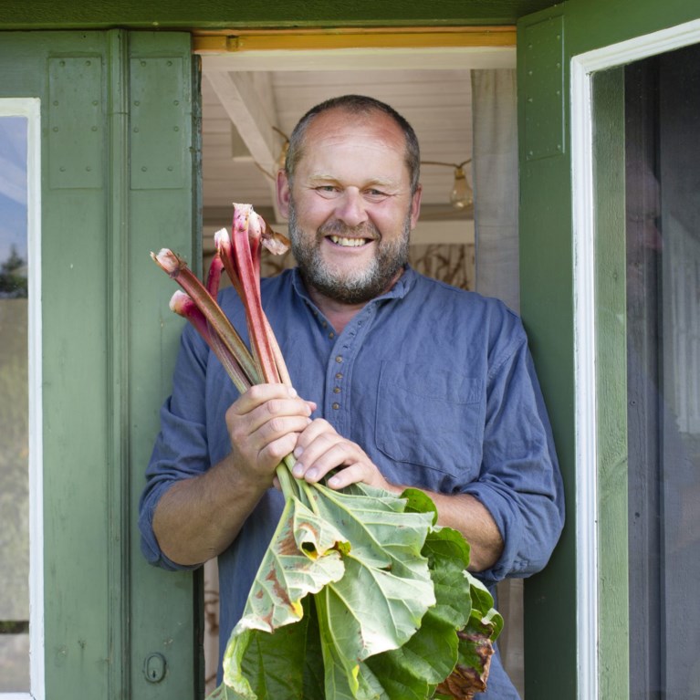 John Taylor håller upp en bukett rabarber