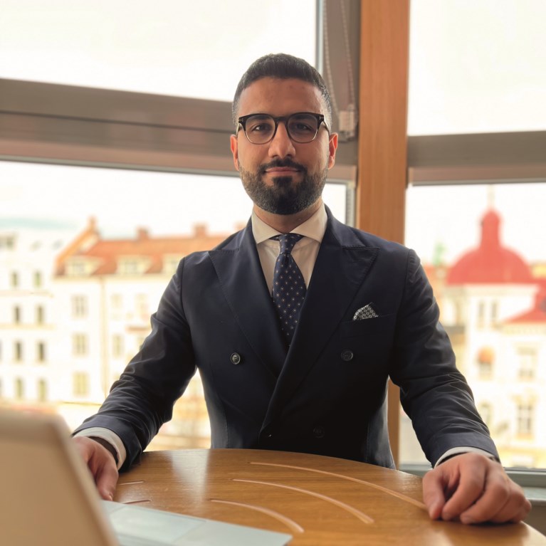 man i kostym vid bord