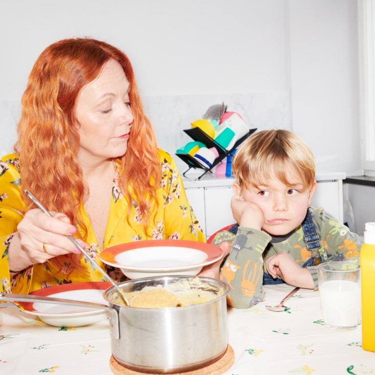 Kvinna och barn sitter vid matbord