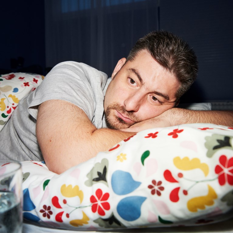 Man som ligger med huvudet på kudde