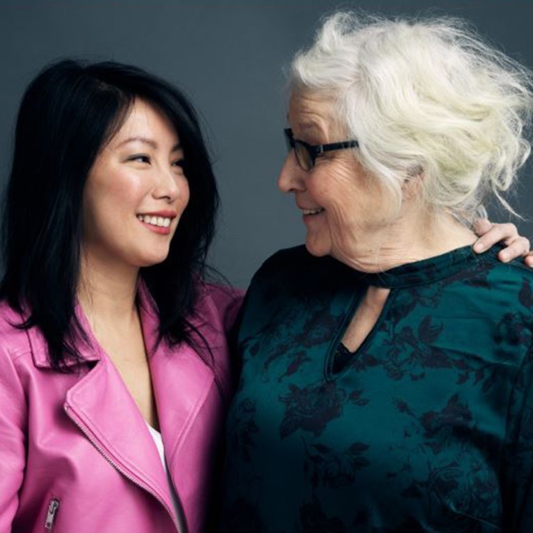 En ung och en äldre kvinna som tittar på varandra och skrattar.