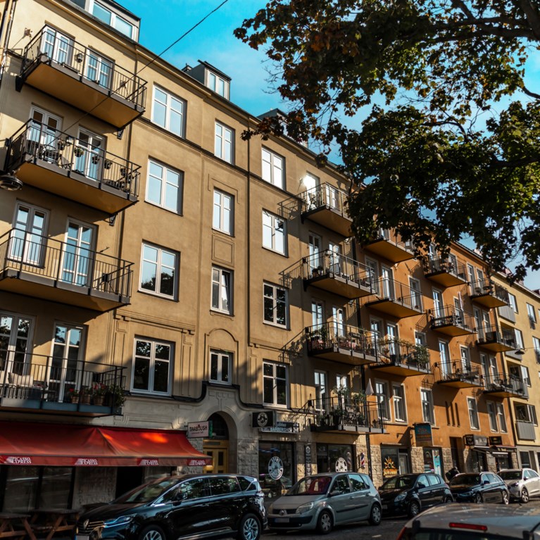 stadsgata med flervåningshus i rad i olika färger.