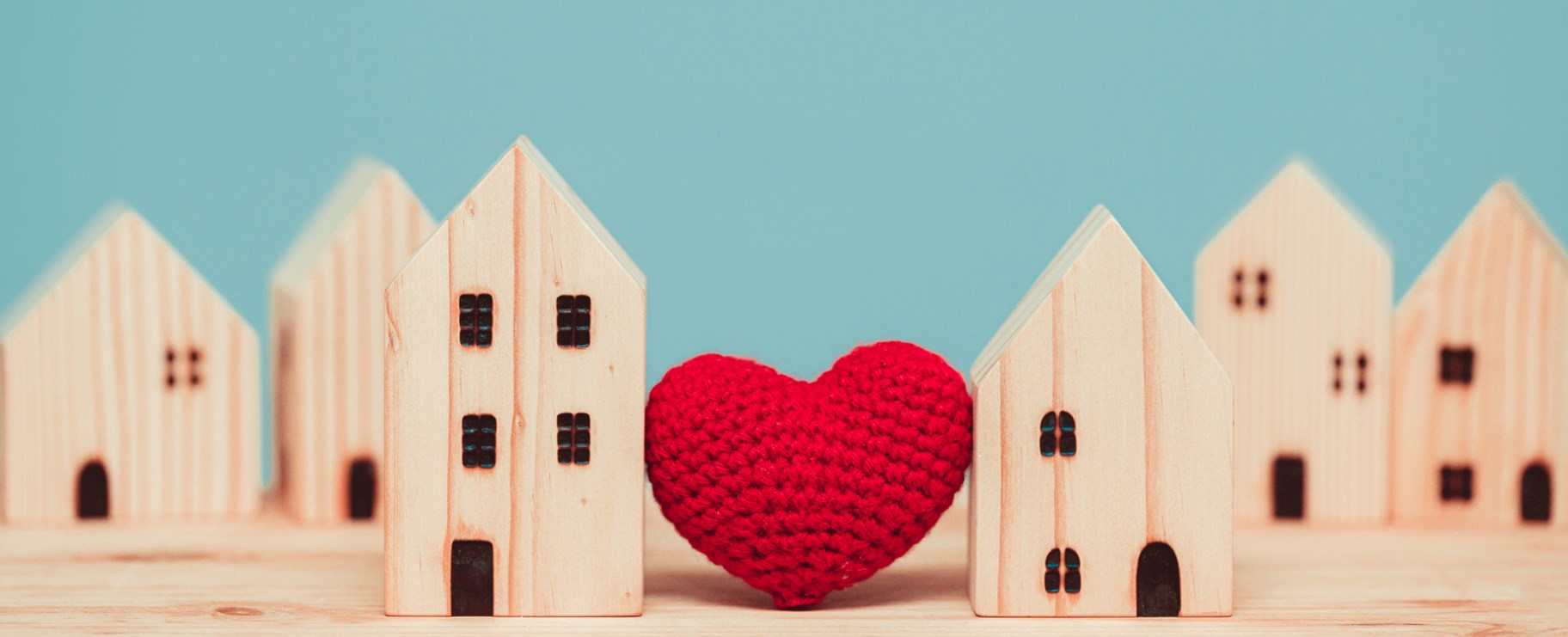 Trähus prototyper med ett rött hjärta mellan sig.
