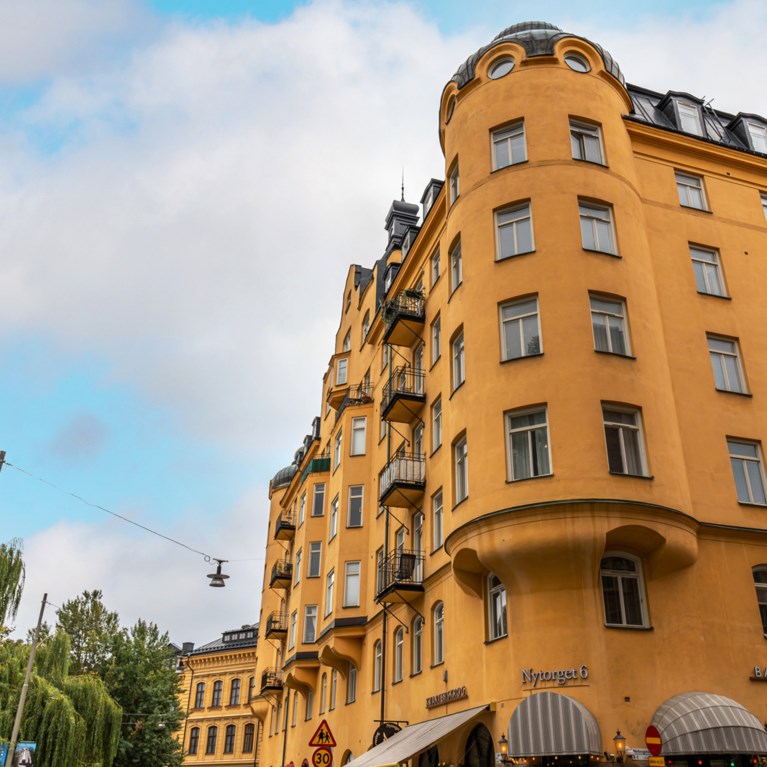 En vacker äldre gul fasad med rundat burspråk.