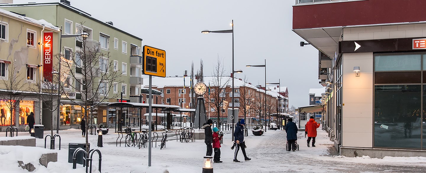 Vy över ett torg i Boden. Vinter med människor på bild.