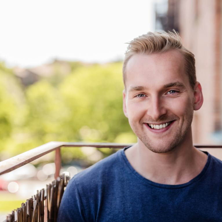 Man sitter på sin balkong