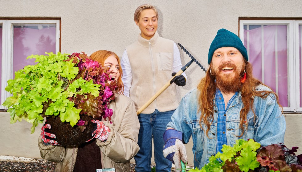 Tre människor med blommor och odlingsverktyg