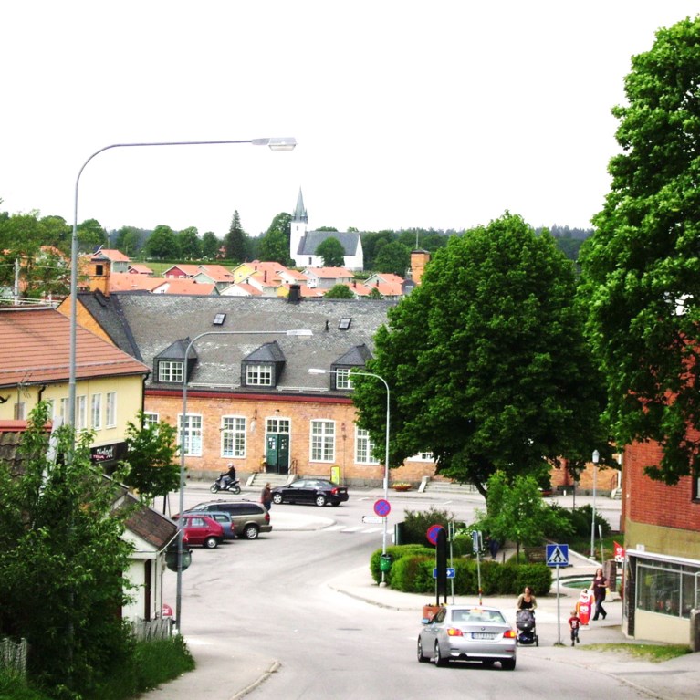 Stadsmiljö i nerförsbacke med kyrka i fonden