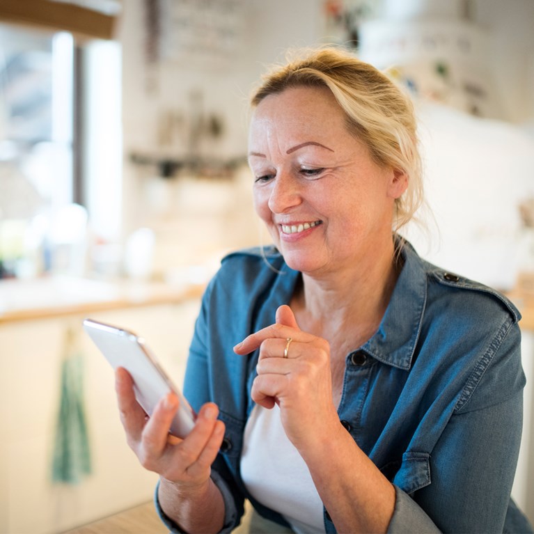 Glad kvinna med mobil