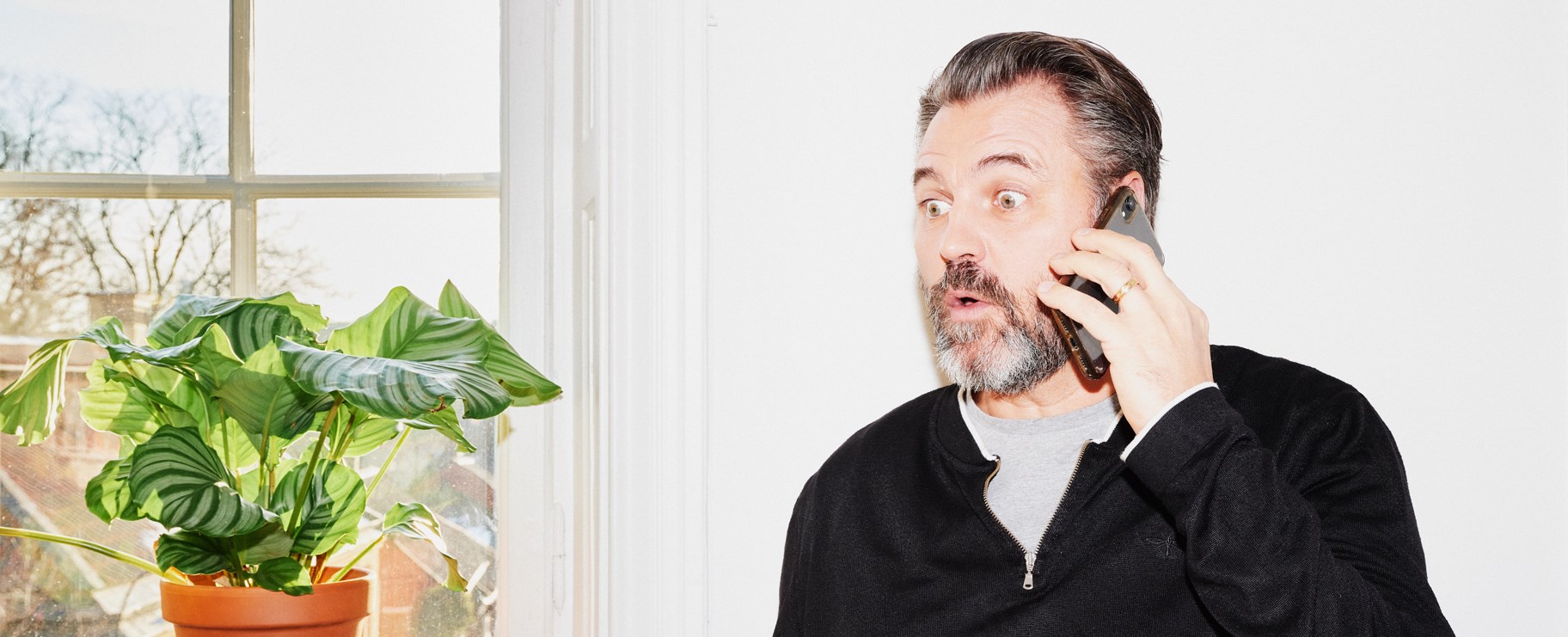 Förvånad man i telefon.
