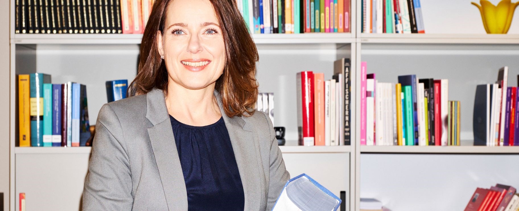 Glad kvinna håller i en lagbok.