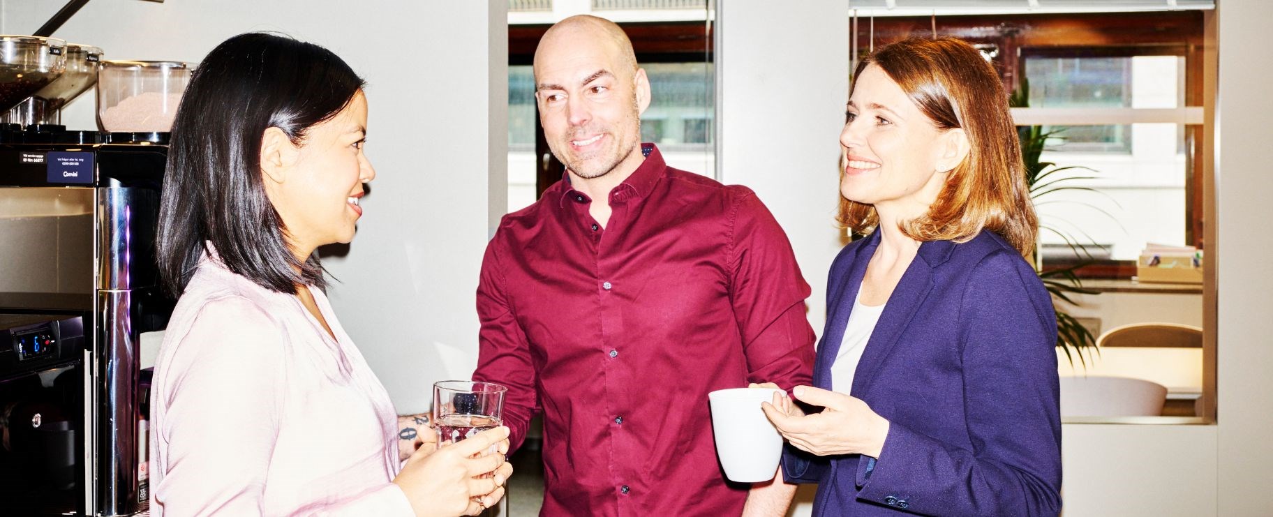 Tre glada kollegor i fikarummet