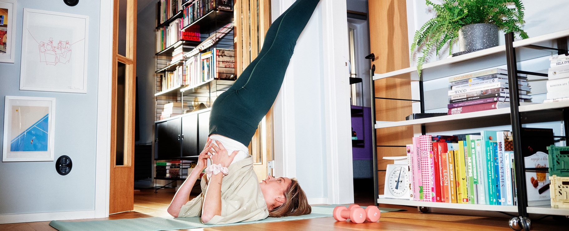 Kvinna tränar yoga hemma i lägenheten.