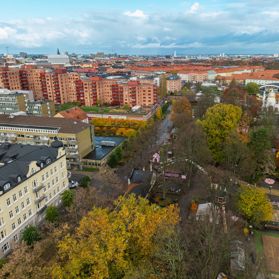 Bild på fleras fastighetshus bredvid en park