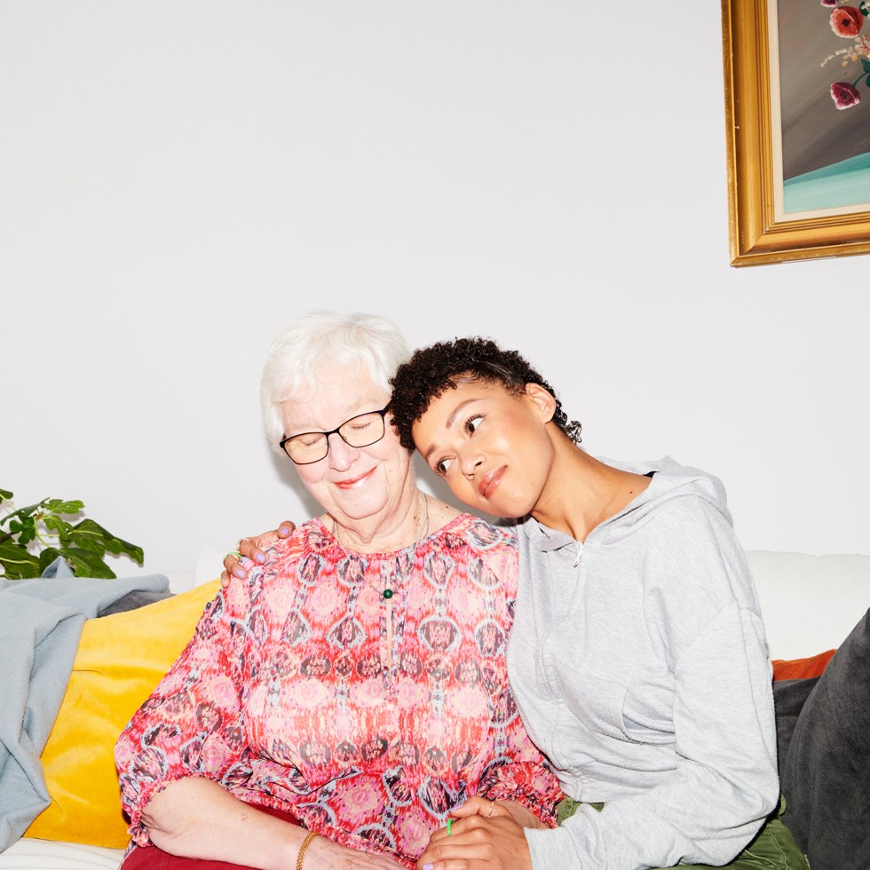 Ung kvinna kramar om äldre dam