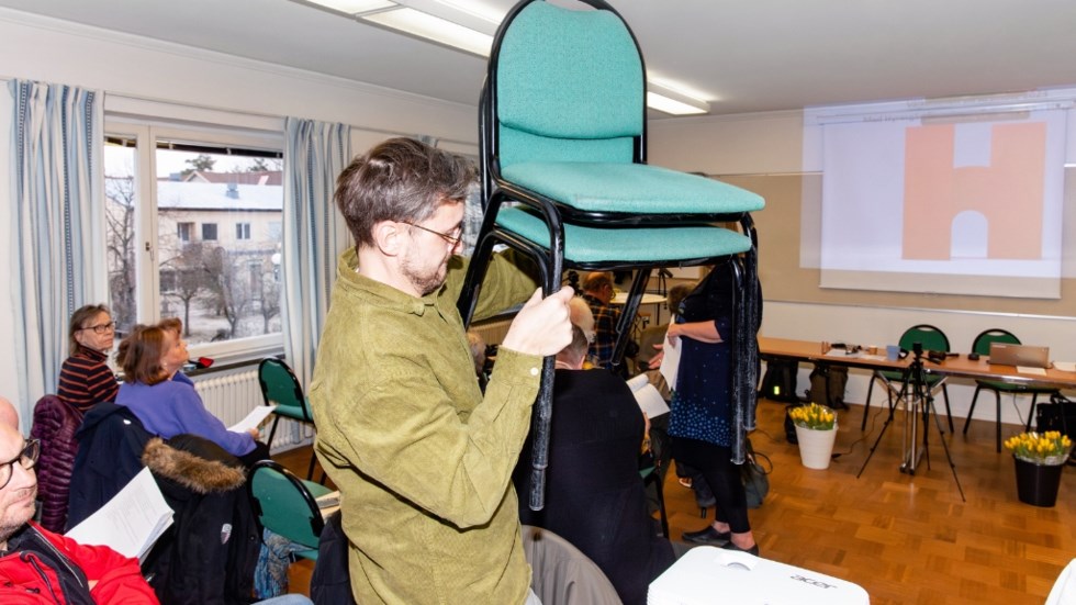 Man bär på två stolar.