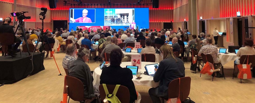 Foto från stämmosalen i Göteborg 2023. På bilden syns ombud som sitter runt runda bord och kollar mot scenen.