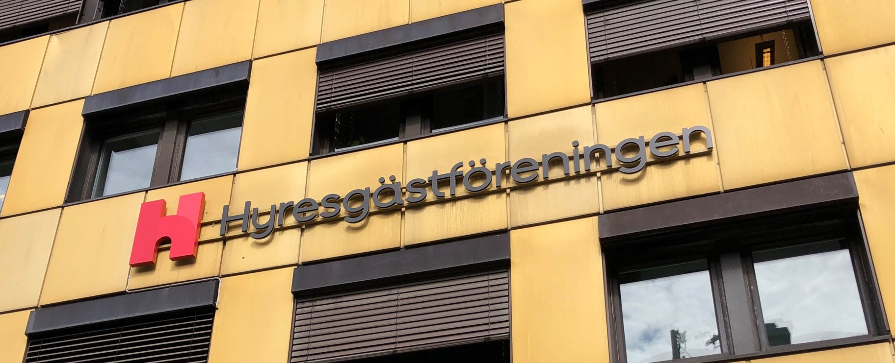 Foto på fasaden till regionkontoret, som är en gul plåtfasad med en stor skylt där det står Hyresgästföreningen.