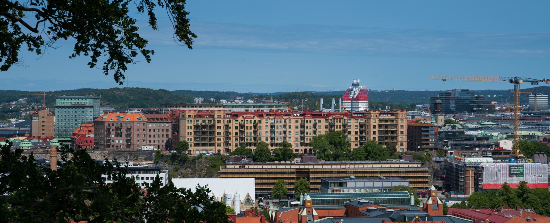 Foto över stadsdelen Centrum där man ser husfasader och ett träd i förgrunden