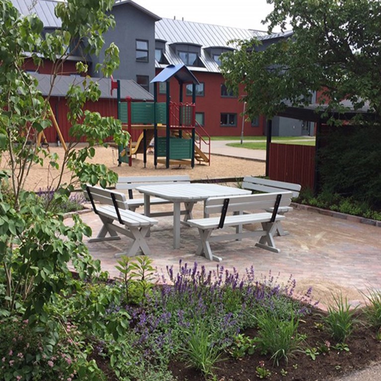 Uteplats med stenläggning och buskar