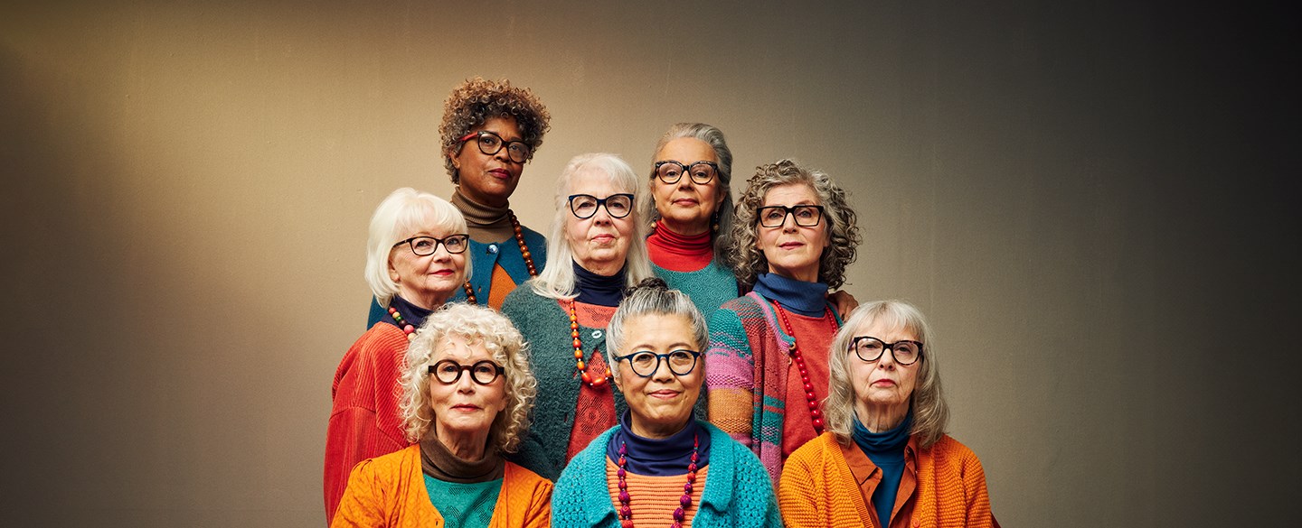 En grupp kvinnor med svarta glasögon, kofta och stora halsband