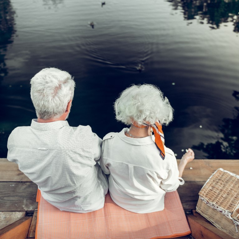 äldre sitter vid vattnet