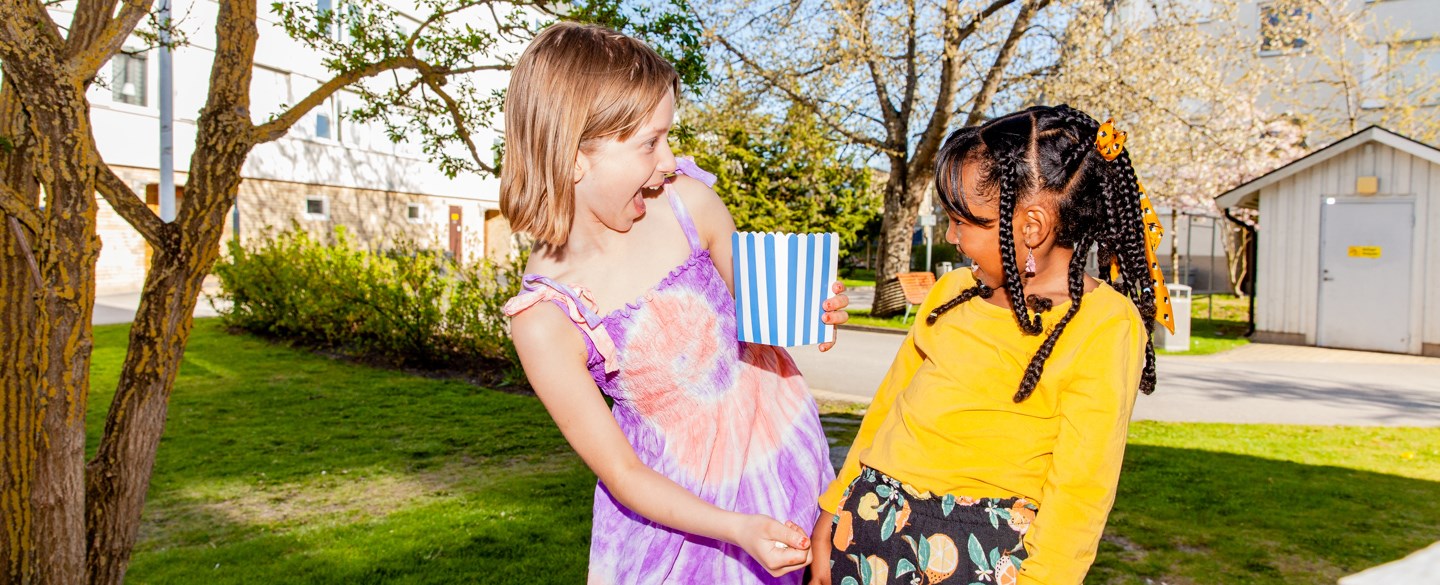flicka står på gården med popcorn i handen