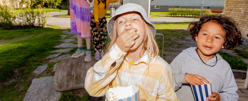 två små pojkar äter popcorn