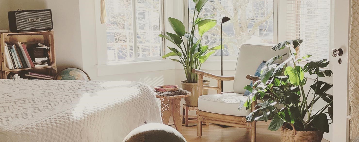 En fåtölj och växter i ett vardagsrum