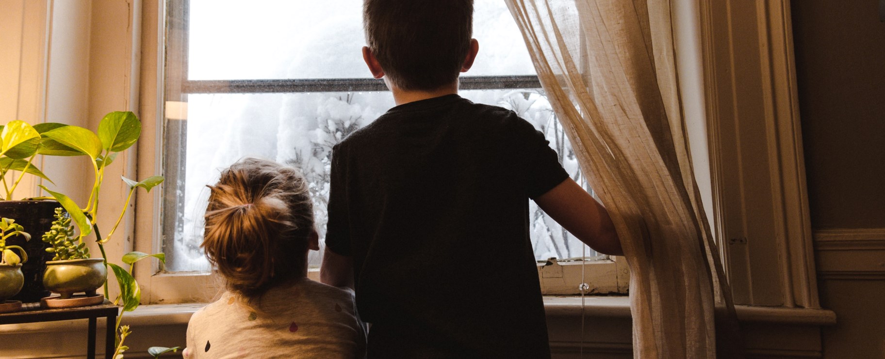 Barn tittar ut genom fönster