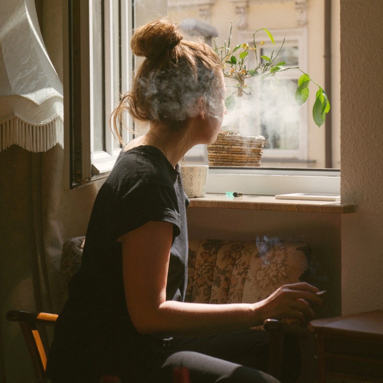 kvinna röker i fönster