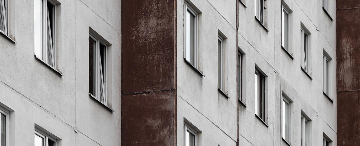 Bilden visar en grå husfasad