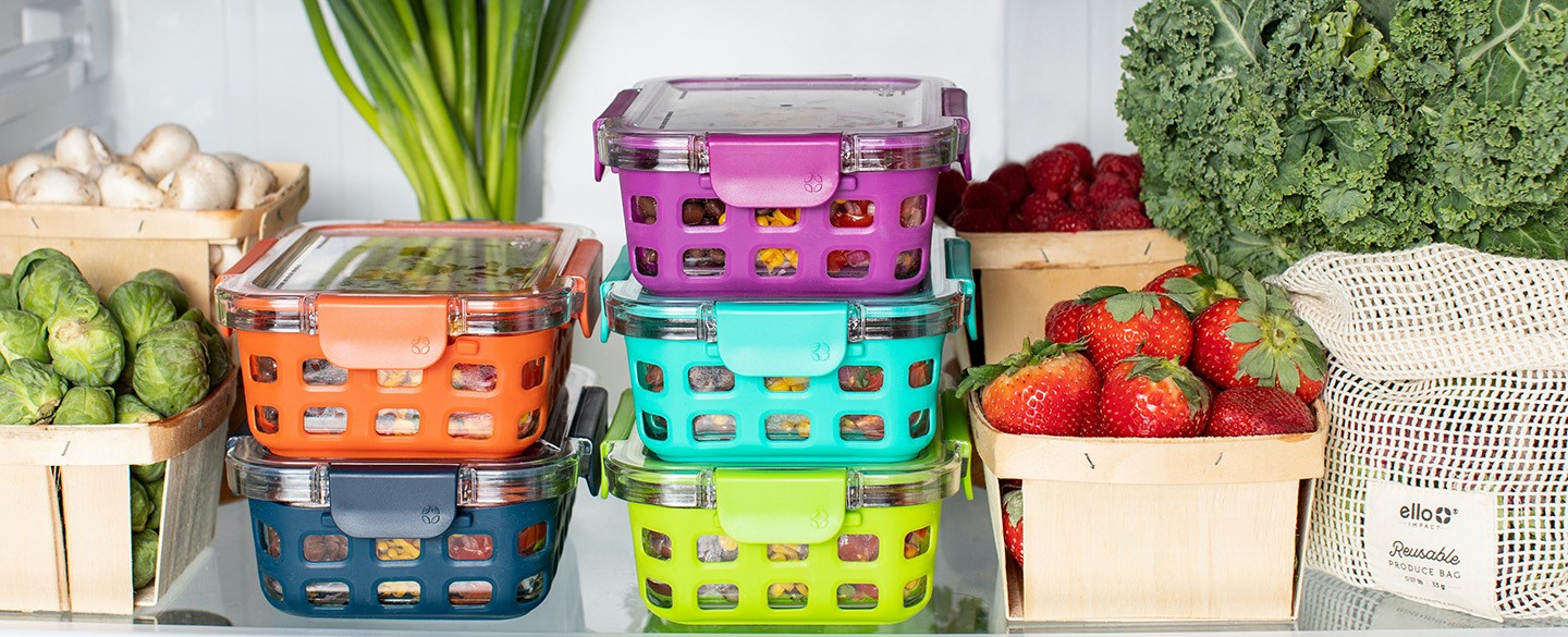 Hylla i kyl med matlådor, grönsaker och frukt
